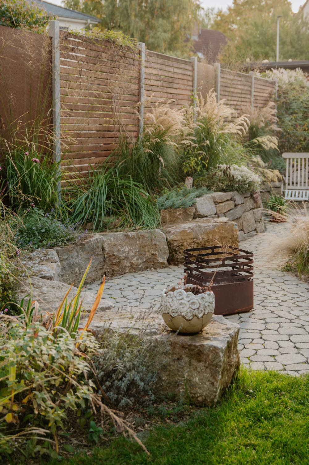 Garten mit Natursteinmauer, gepflasterter Fläche und Sitzbereich