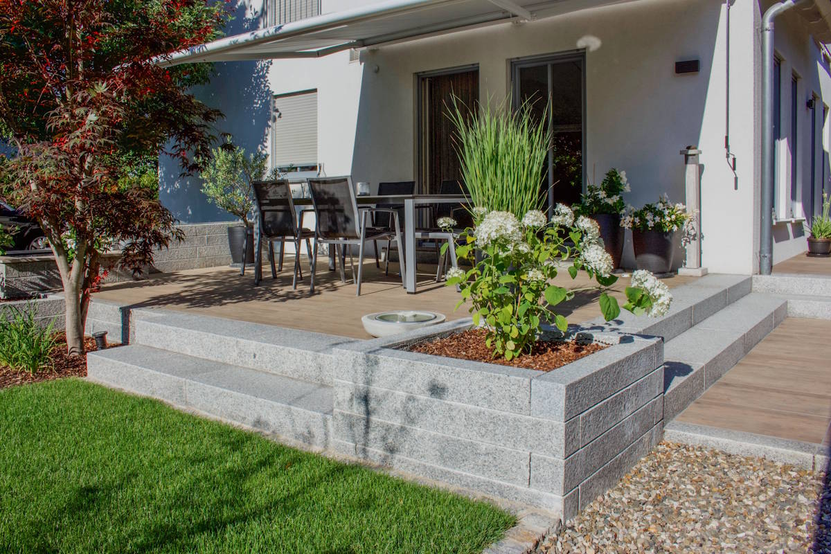Gepflasterte Terrasse mit Sitzbereich und abgestimmter Bepflanzung