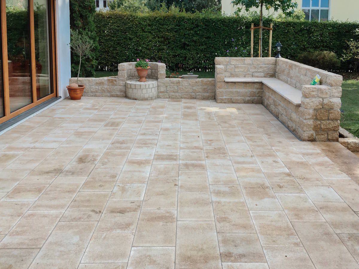 Großzügige Terrasse mit Natursteinoptik und Gartenzugang