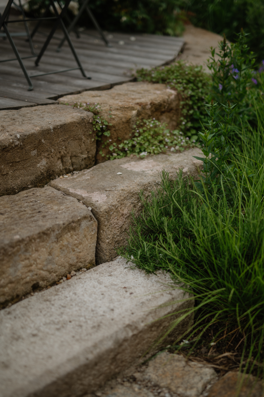 Treppe aus Sandsteinblöcken an Holzterrasse